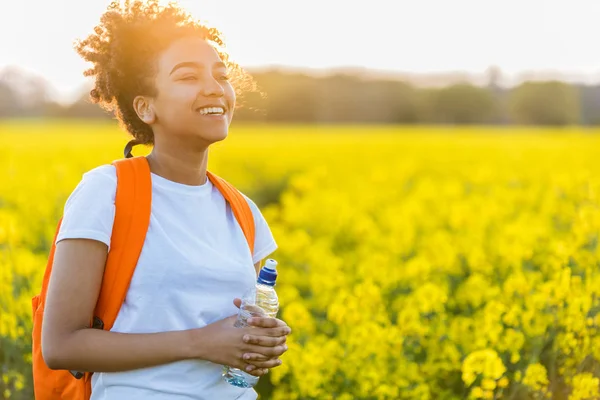 Gemischte Rasse afrikanisch-amerikanische Mädchen Teenager in gelben Blumen bei s — Stockfoto