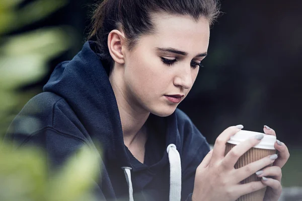 Triste adolescent jeune femme boire du café à l'extérieur — Photo