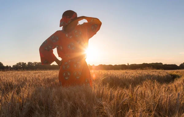 Afrikanerin in traditioneller Kleidung steht auf einem Feld — Stockfoto