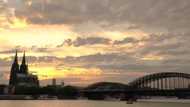 CATHÉDRAL DE COLOGNE, COLOGNE, ALLEMAGNE - 31 JUILLET 2017 : clip vidéo 4K du coucher de soleil derrière la cathédrale de Cologne, trains sur le pont Hohenzollern et navire-citerne naviguant sur le Rhin, Allemagne — Video