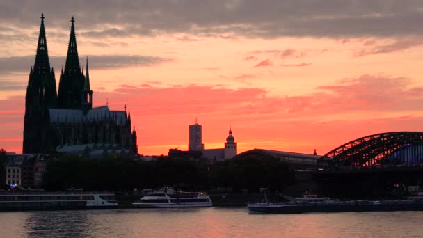 Köln Katedrali, Köln, Almanya - Temmuz 31 2017:4 k video klip Köln Katedrali, trenler Hohenzollern köprü ve nehir Ren, Almanya üzerinde yelken tanker gemisi arkasında günbatımı — Stok video
