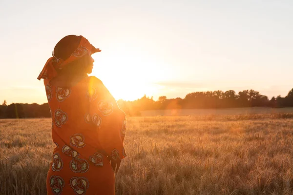 African woman in traditional clothes standing in a field of crop — Stock Photo, Image