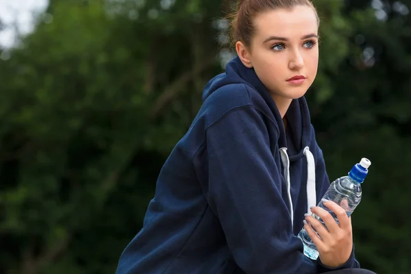 Triste adolescente jovem mulher bebendo garrafa de água — Fotografia de Stock
