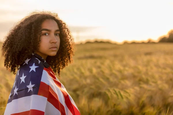 Triste depresso ragazza donna adolescente avvolto in USA Bandiera al tramonto — Foto Stock