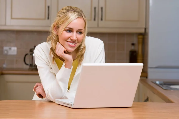 Mooi tiener meisje jong vrouw met behulp van laptop computer in haar keuken thuis — Stockfoto