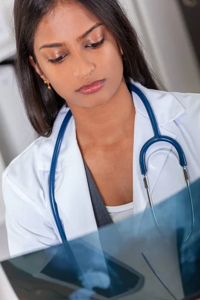 Asiatische indische Krankenhausärztin betrachtet Röntgenbild einer Hüftprothese — Stockfoto