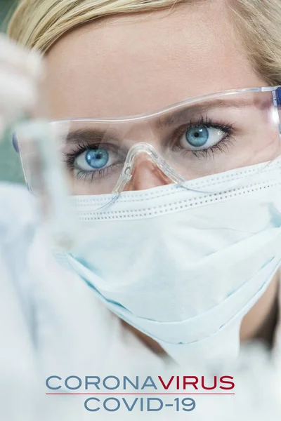 女性の医学研究者や医師は コロナウイルスCovid 19実験室や実験室でサンプル試験管を見て顔マスクを着用します テキスト付きの写真 — ストック写真