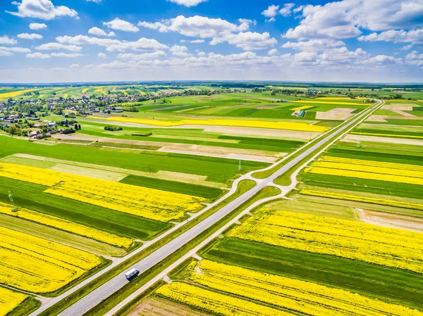 Vägen löper genom färgglada fält. Gröda fält sett från luften. — Stockfoto