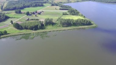Su ve ekili alanlar üzerinde uçuş. Kuş bakışı görülen bir göl ile kırsal manzara. Lehçe manzara havadan gördün.
