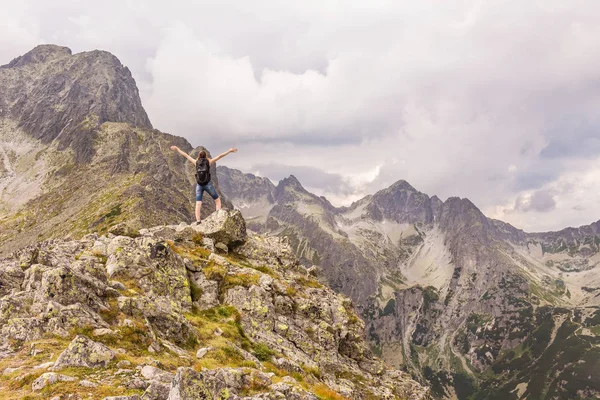 Tatry mountains landscape with a coming storm. A woman who enjoys climbing a mountain peak.