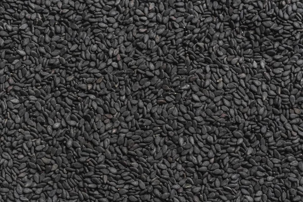 Grains of black sesame seeds. Background from black grains. texture from black seeds.