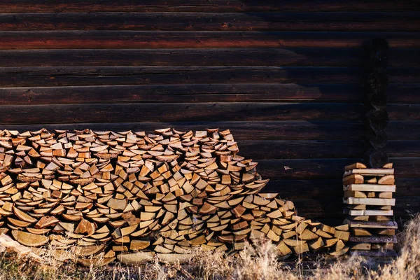 Firewood empilhado perto da cerca — Fotografia de Stock