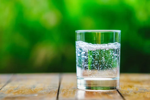 Ein Glas Wasser auf grünem Hintergrund — Stockfoto