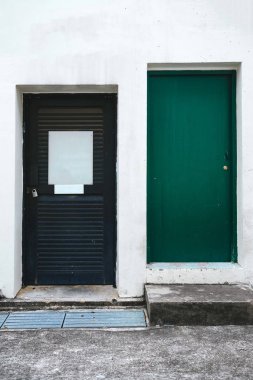 Eski yeşil kapı önünde beyaz bir duvar. Sokakta. Kötü durumda