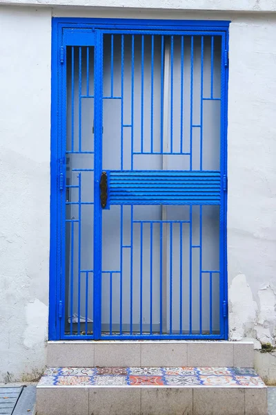 Porte bleue la calandre à l'avant d'un mur blanc — Photo