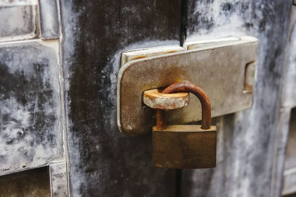 Rusty padlock. On metal doors. Closed door