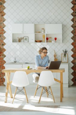 Karantina sırasında evde çalışıyorum. Tuğla çerçeveli beyaz mutfak. Parlak güneş. Sıcak atmosfer