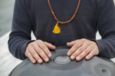 Man' s hands playing hang drum  clipart
