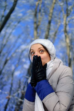 Büyük gözlü oynak kız gülümseme elleri altında gizler. Portra