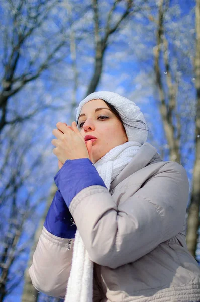 Молодая женщина пытается согреть свои замороженные руки в Зимнем парке дю — стоковое фото