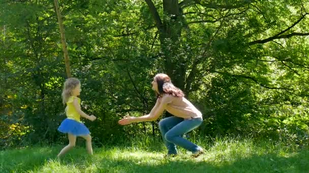 Feliz Madre Atractiva en Camisa Rosa y Jeans Recogiendo a su Hijita en el Parque durante el Soleado Día Cálido . — Vídeo de stock