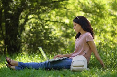 genç esmer kız dizüstü bilgisayar açık havada ile çalışma