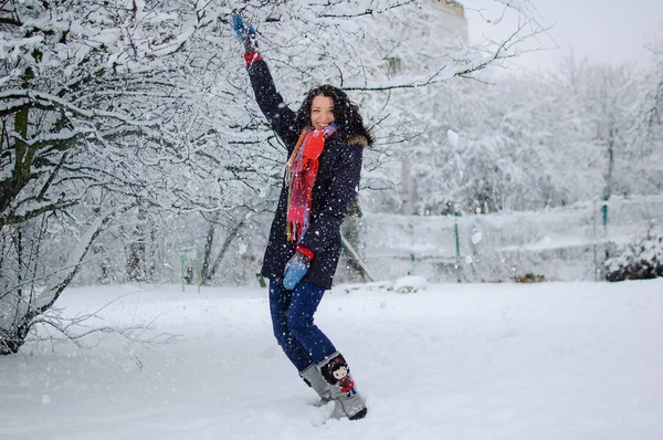 All'aperto Ritratto di giovane ragazza sorridente che indossa una sciarpa rossa e si diverte all'aperto nel parco innevato durante il periodo invernale . — Foto Stock