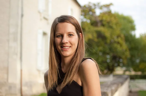 Retrato ao ar livre da menina atraente com cabelos longos brilhando em pé no fundo do castelo durante o pôr do sol no verão . — Fotografia de Stock