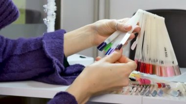 Örnek paletindeki kadın elleriyle doğal manikür ve ultraviyole seçerek kısa çivi çivi.