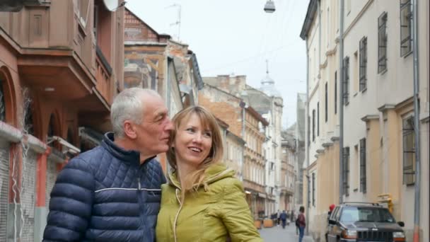 Portrét šťastného romantického páru s rozdílem stáří, který se ve starověkém městě na začátku jara nebo na podzim objímat venku. — Stock video