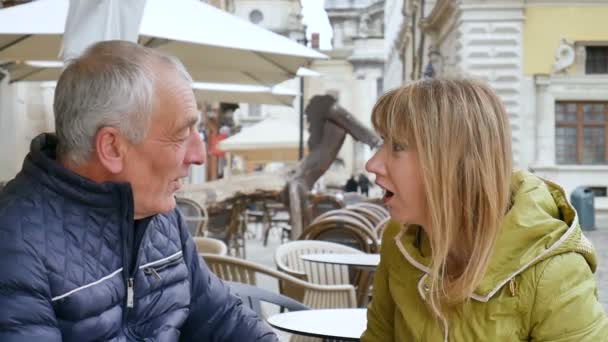 Красивый пожилой мужчина обнимает свою молодую блондинку жену, проводя время вместе на свежем воздухе в древнем городе ранней весной или осенью. . — стоковое видео