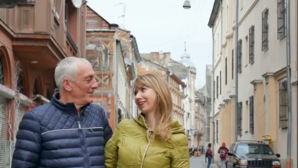 Retrato de pareja romántica feliz con diferencia de edad abrazándose al aire libre en la ciudad antigua durante principios de primavera u otoño . — Vídeos de Stock