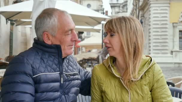 Hombre mayor guapo está abrazando a su joven esposa rubia pasar tiempo juntos al aire libre en la ciudad antigua durante principios de primavera u otoño . — Vídeos de Stock