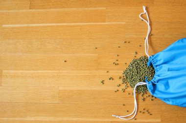 Ahşap arka plan üzerinde mavi yeniden kullanılabilir paket yeşil mung fasulye. Kopyalama alanı
