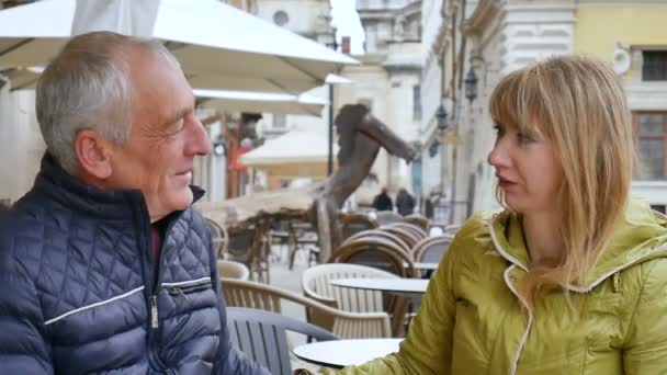 Beau vieil homme embrasse sa jeune femme blonde passer du temps ensemble à l'extérieur dans la ville antique au début du printemps ou de l'automne . — Video