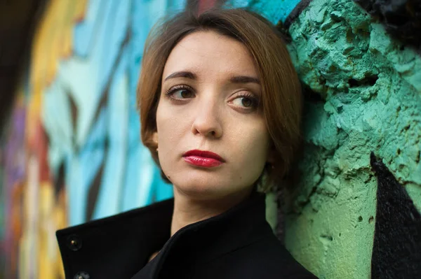 Close-up retrato feminino de jovem menina triste com cabelo loiro curto em depressão perto da parede com graffiti. Cultura juvenil, conceito de arte de rua — Fotografia de Stock