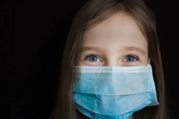 Coronavirus Covid-19 outbreak. Little girl is looking at the camera with hope. Stay positive concept during self-isolation at home wearing personal protective mask — Stock Photo, Image