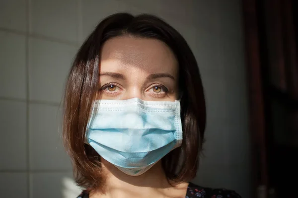 Coronavirus Covid-19 outbreak. Young woman on home isolation wearing surgical mask on the face for protection from virus during pandemia — Stock Photo, Image