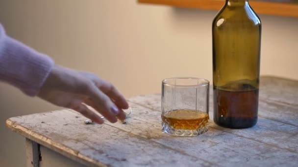 La mano femenina pone la llave sobre la mesa y toma un vaso de whisky para beber, concepto de adicción al alcohol — Vídeos de Stock