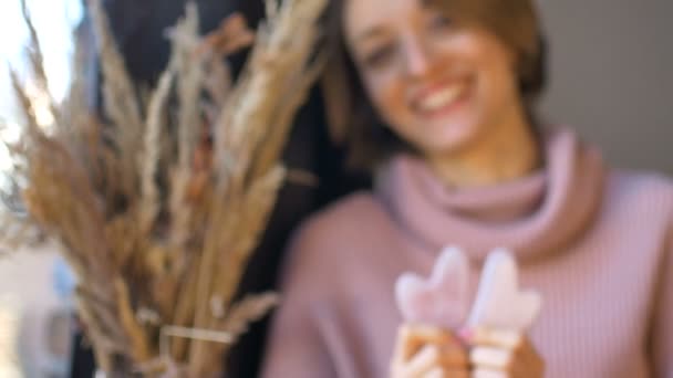 Donna sta mostrando un massaggio massaggiatori gua sha a base di pietra naturale quarzo rosa a forma di cuore che vengono utilizzati per stimolare il sistema linfatico e ha effetto anti età — Video Stock