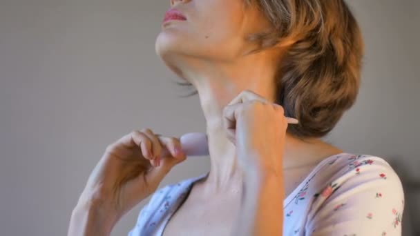 The girl makes a massage gua sha in front of the mirror at home using rose quartz massager, natural stone. Lifting, stimulate lymphatic system and anti age effect — Stock Video