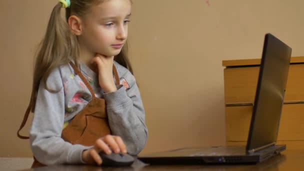 Meglepett, hogy a fáradt kislány megpróbálja megcsinálni a bonyolult házi feladatát fekete laptoppal, és fogalma sincs, hogyan kell befejezni az önelkülönítés során a Coronavirus Covid-19 járványa miatt. — Stock videók