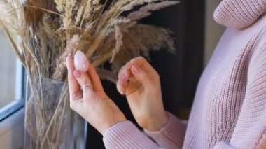 Dikenli arka planda gül kuvars taşından yapılmış yumurta tutan kadınlar. Kadın sağlığı konsepti, vumfit, imbuilding veya meditasyon