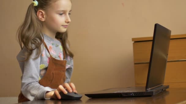 Шокирован, что уставшая маленькая девочка пытается сделать свою сложную домашнюю работу, используя черный ноутбук и понятия не имеет, как закончить во время самоизоляции из-за пандемии Coronavirus Covid-19 — стоковое видео