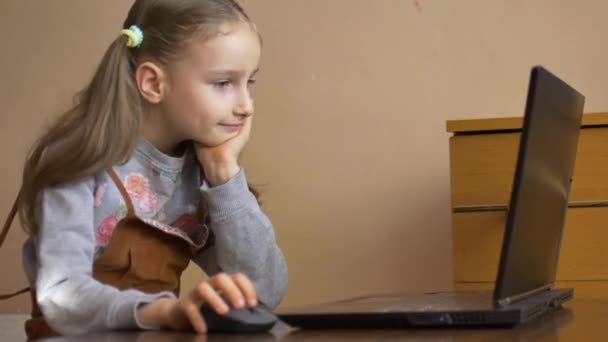 Pequena aluna está estudando em casa com seu professor usando bate-papo por vídeo em seu laptop preto por causa do auto-isolamento devido à pandemia de Coronavirus Covid-19 — Vídeo de Stock