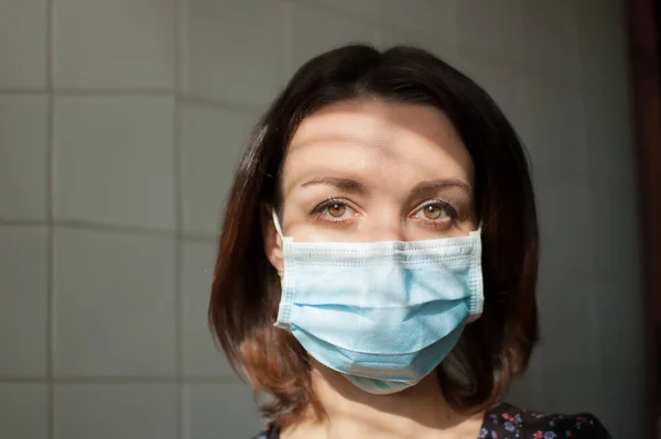 Epidemia Covida-19. Młoda kobieta w izolacji domowej w masce chirurgicznej na twarzy dla ochrony przed wirusem podczas pandemii — Zdjęcie stockowe