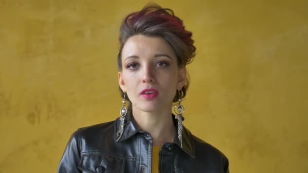 Lets rock concept. Portrait of excited beautiful woman with dark pink hair in casual yellow dress standing, looking at camera, showing rock and roll gesture. — Stock Video