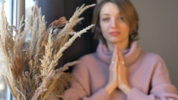 Kvinna håller yoni ägg gjorda av transparent violett ametist sten står nära fönstret med vas av spikelets. Koncept för kvinnors hälsa, vumfit, imitation eller meditation — Stockvideo