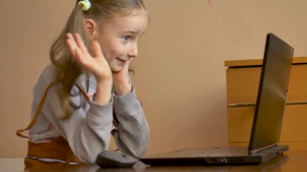 Pequeña alumna está estudiando en casa con su maestra usando video chat en su portátil negro debido al autoaislamiento debido a la pandemia de Coronavirus Covid-19 — Vídeos de Stock