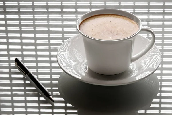 Tasse de café sur la table avec le stylo — Photo